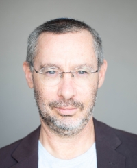 Headshot photo of Shmuel Rosner against a gray background.