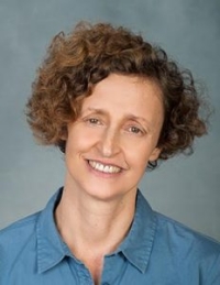 Headshot photo of Dr. Gila Stopler against a bluish gray background. 
